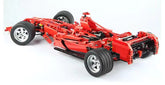 Red car chassis model made of interlocking bricks on a white background